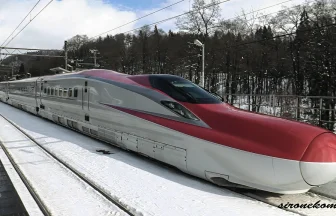 雪の中を駆け抜ける秋田新幹線E6系とE3系こまちの走行シーン